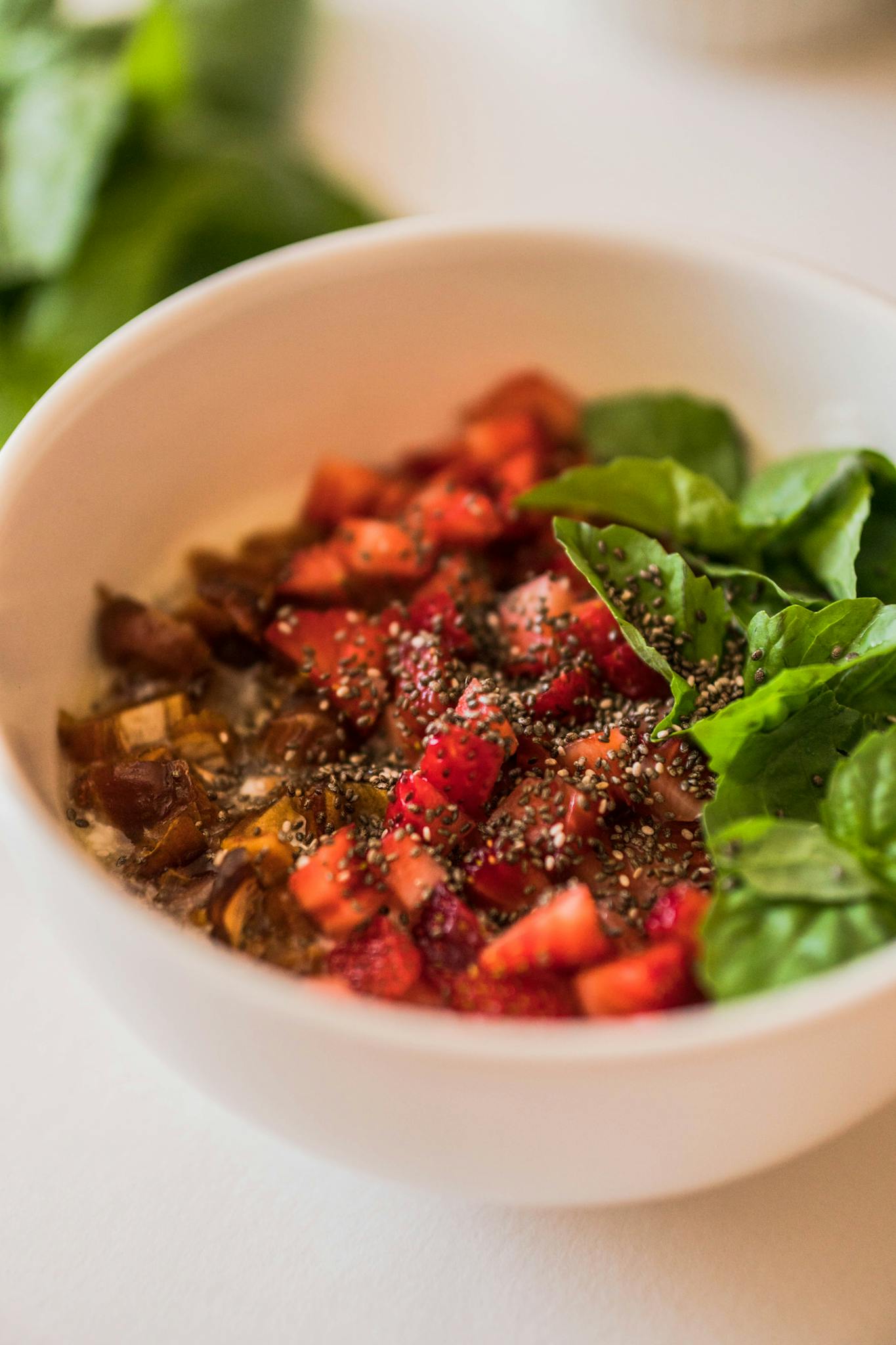 A vibrant breakfast bowl featuring fresh greens, strawberries, chia seeds, and more for a nutritious start.